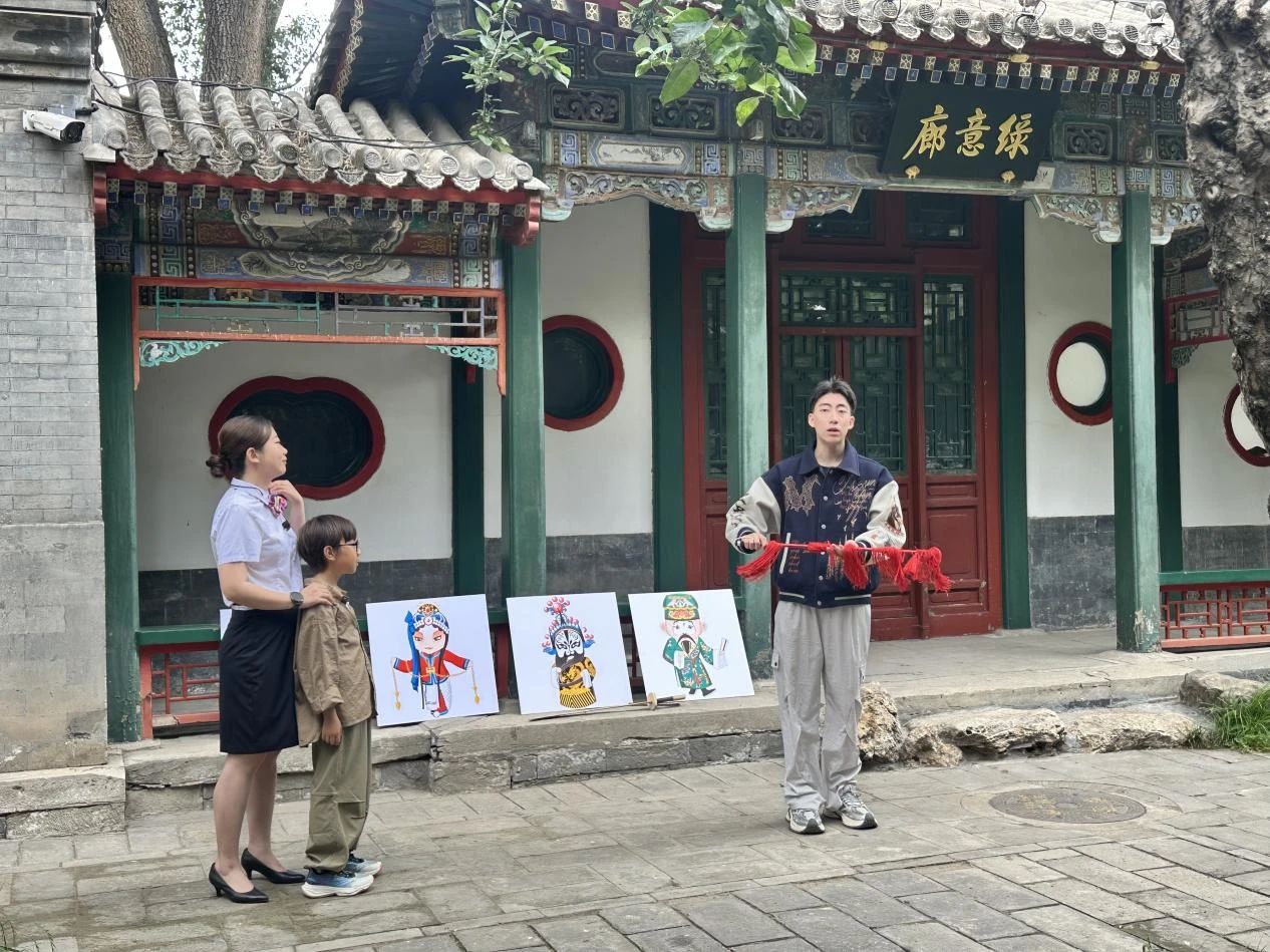 戏曲讲师为游客介绍京剧历史照片