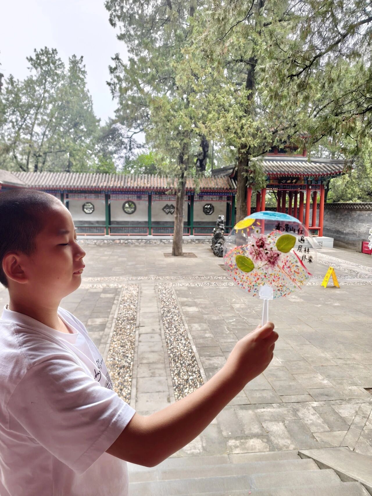 游客手持团扇拍照